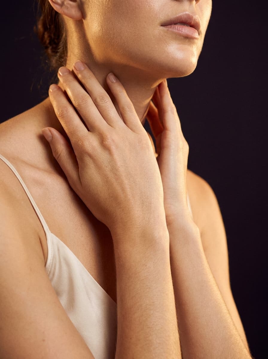 Hands resting at the collarbone